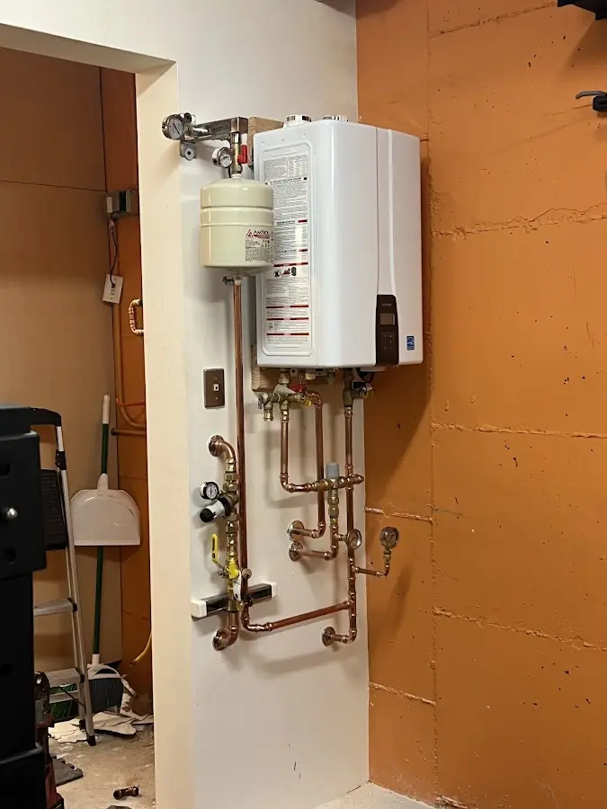 Plumbing technician inspecting water heater connections in Kekaha